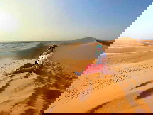 Traveller at on sand dune in the Sahara Desert in Morocco