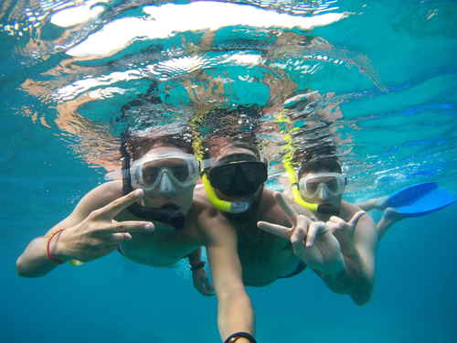 Three travellers underwater in scuba gear