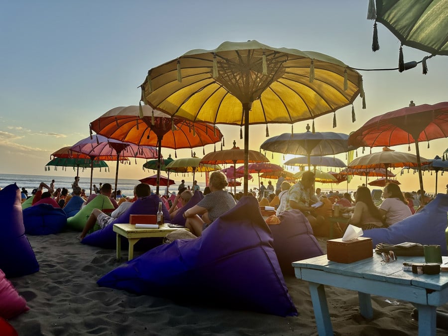 Seminyak beach at sunset with colourful umbrellas in beach bar Bali
