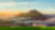 Sunrise over a mountain surrounded by clouds and a town below