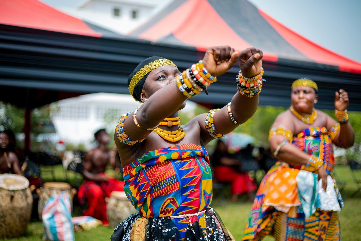 A group of peopl edancing in colourful traditional clothing 