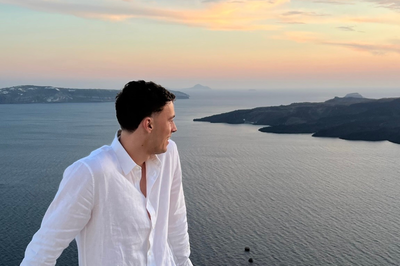 Traveller looking across Greek islands at sunset 